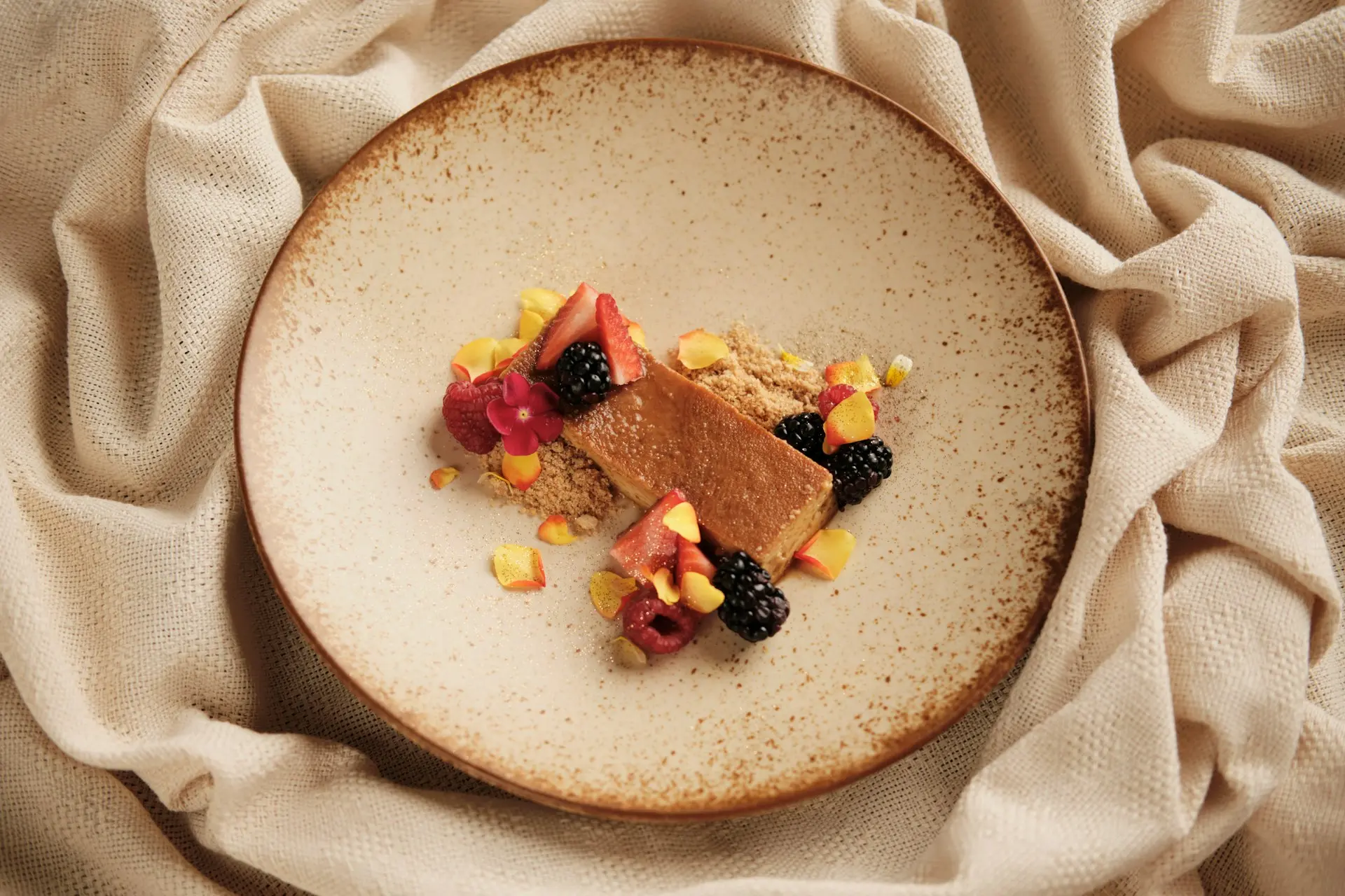 a white plate topped with a piece of cake and fruit